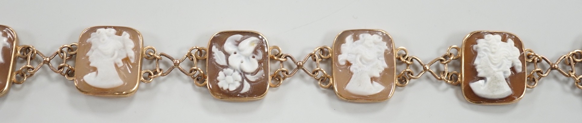 A 1970's 9ct gold and seven cameo panel set bracelet, carved with busts of ladies or flowers, 18cm, gross weight 10.3 grams.